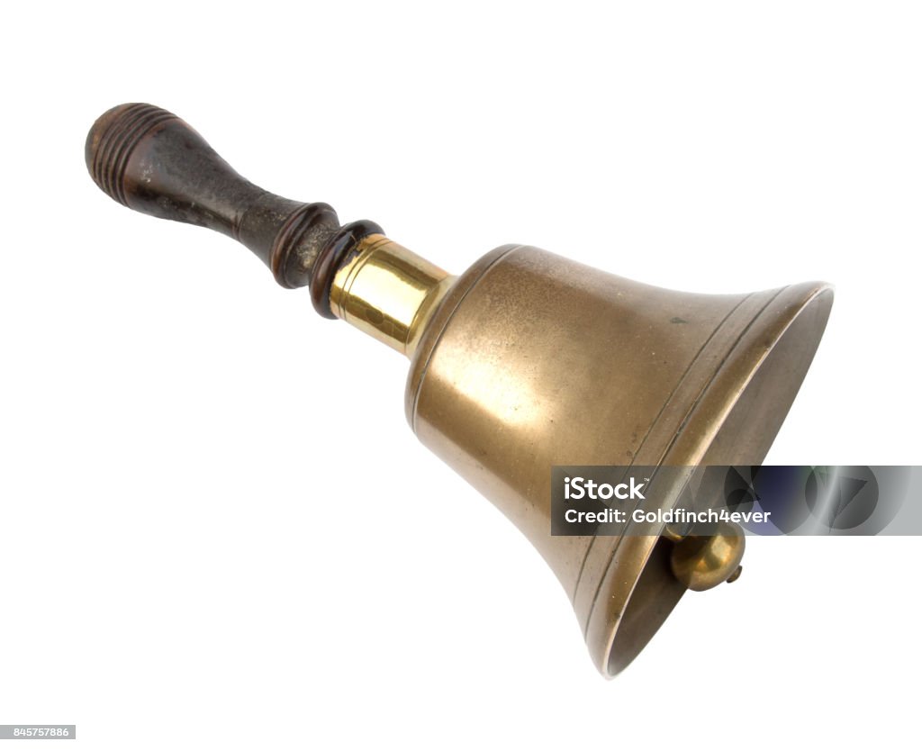 Old brass school bell, isolated on white. Traditional design, wooden handle. Well worn! Bell Stock Photo