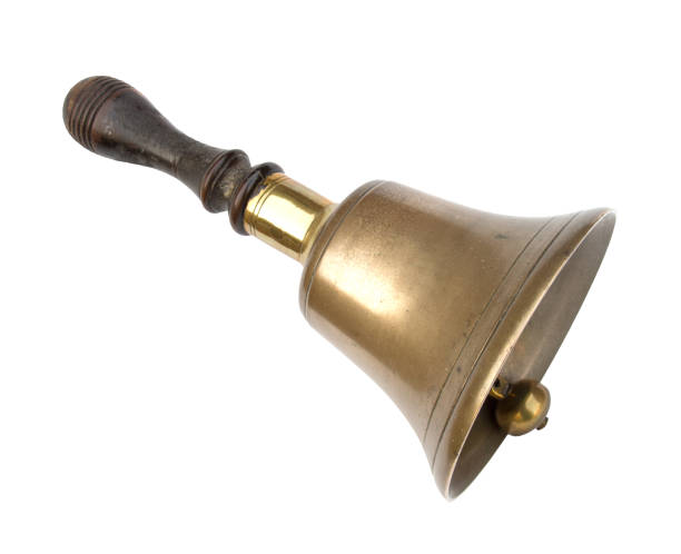 Old brass school bell, isolated on white. Traditional design, wooden handle. Well worn! bell photos stock pictures, royalty-free photos & images