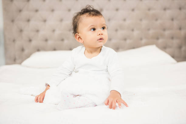 istock Cute baby sitting on bed 845760920