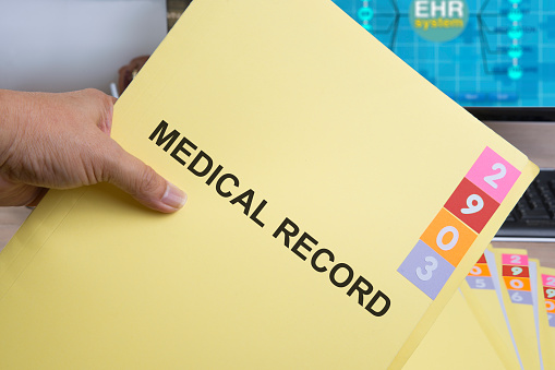 Yellow medical record folder in someone hand.