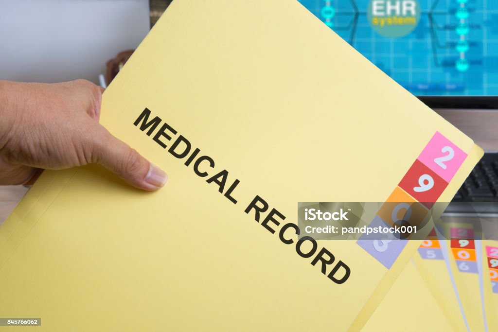 Yellow medical record folder. Yellow medical record folder in someone hand. Medical Record Stock Photo