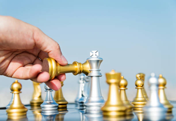 Man hand moving golden king in chess game