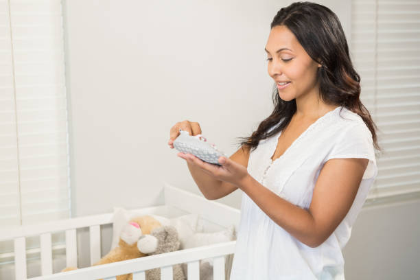 istock Smiling brunette holding baby shoes 845766768