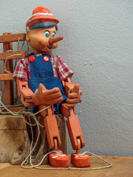 istock Pinocchio puppet made from wood.Sitting on wood box 845775862