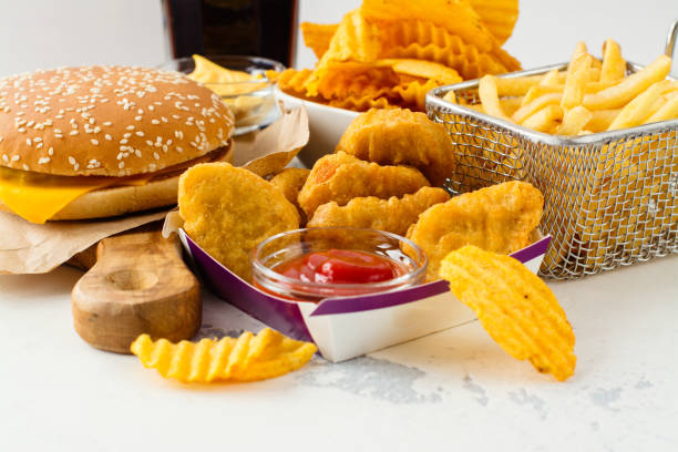 Assortment of fast food Junk food on white table. Fast carbohydrates not good for health, heart and skin unhealthy eating stock pictures, royalty-free photos & images