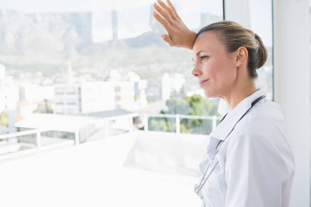 istock Confident female doctor looking through windows 845782014