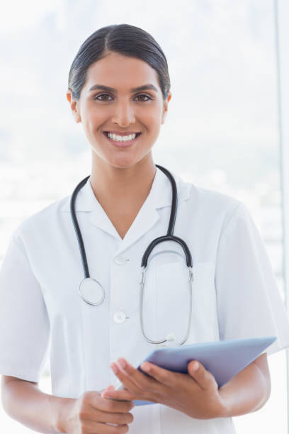 istock Happy doctor holding clipboard and smiling at camera 845782212