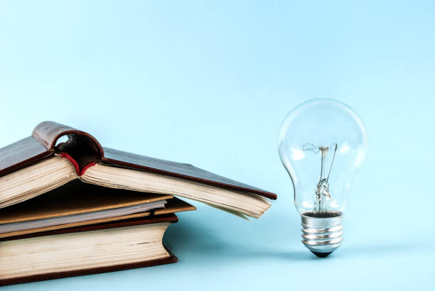 istock Books and light bulb on blue background close-up 845782520