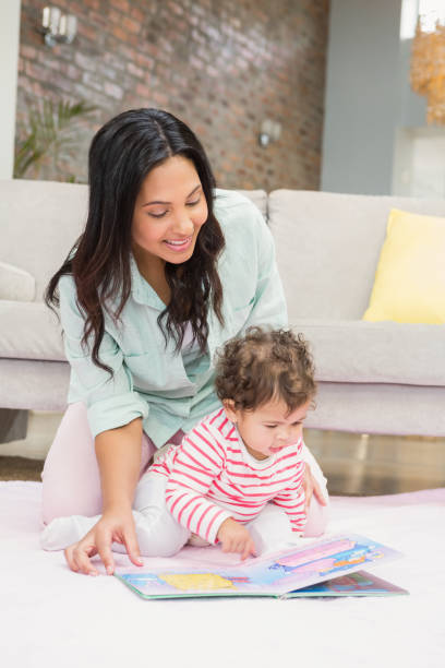 istock Happy mother with her baby looking at a book 845790204