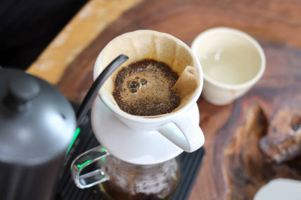 istock Hand drip coffee.  Ground coffee beans in a paper filter with hot water. 845790764