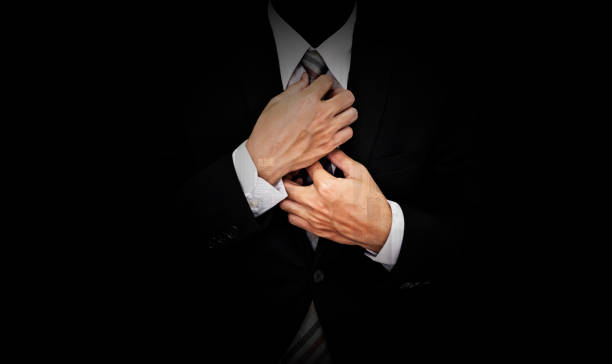 istock Businessman in black suit on black background 845799848