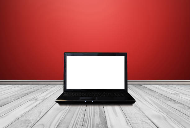 istock Computer laptop with blank empty white screen, on white wood floor with red wall. Clipping path on screen 845799918