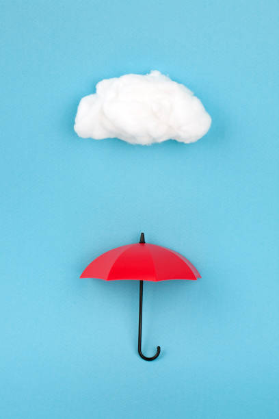 istock red umbrella under the cloud on sky blue background 845809800
