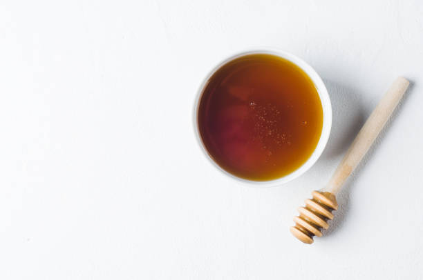 istock Fresh honey in a white cup on a white concrete background 845817872