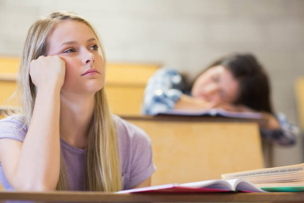 estudante entediada enquanto colega dormindo - sleeping high school desk education - fotografias e filmes do acervo