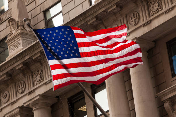 amerikanische flagge im finanzviertel von manhattan, new york city - wall street new york stock exchange american flag manhattan financial district stock-fotos und bilder