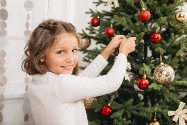 istock girl decorating christmas tree 845836156