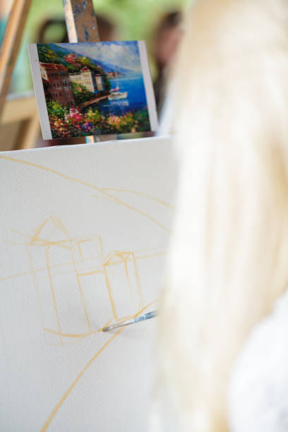 istock artist's hand with brush painting on canvas 845836990