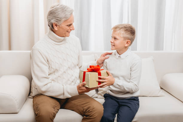 istock grandfather presenting christmas gift to grandson 845837318