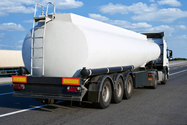 oil truck on road with blank cistern and cloudy sky, cargo transportation concept Truck on road with container and cloudy sky, cargo transportation concept fuel truck photos stock pictures, royalty-free photos & images