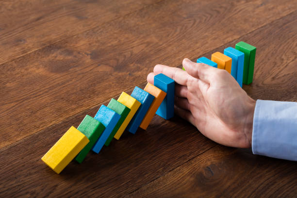 istock Person Hand Stopping Dominoes 845844036
