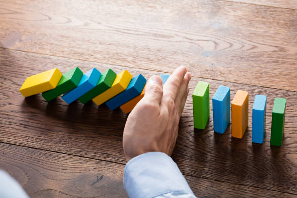 istock Person Hand Stopping Dominoes 845844354