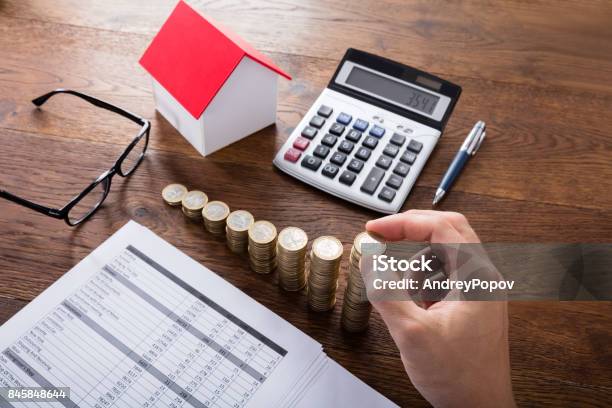 Person Stacking Coins On Wooden Desk Stock Photo - Download Image Now - Adult, Adults Only, Budget