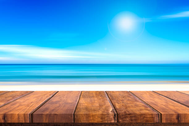 istock Wooden table sand beach blue sky 845851272