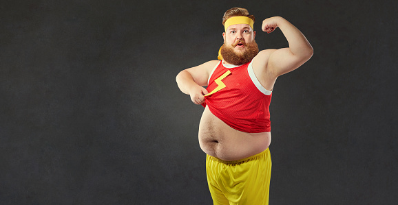 A Funny Fat Man With A Big Belly Shows The Muscles On His Arm Stock Photo -  Download Image Now - iStock