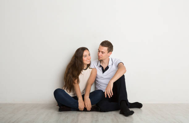 istock Happy couple looking at each other on floor 845860654
