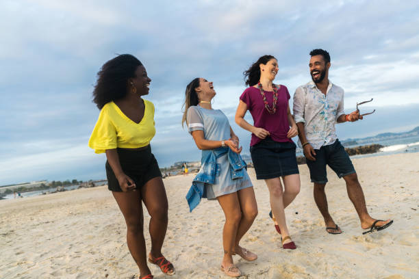 istock cheerful multi-ethnic friends walking at beach against sky 845863698