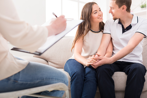 Happy couple reconciling at therapy session in psychotherapists office