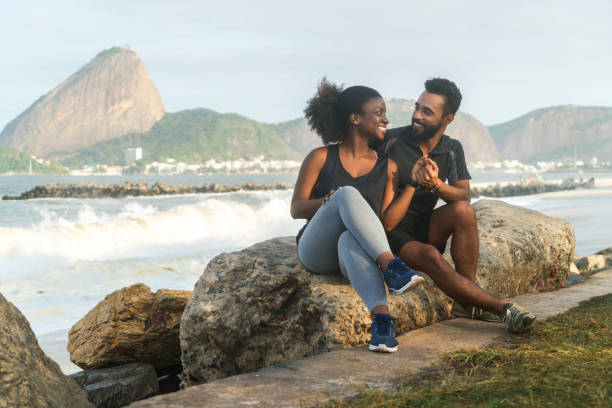 istock sporty couple sitting on rock at beach 845864142