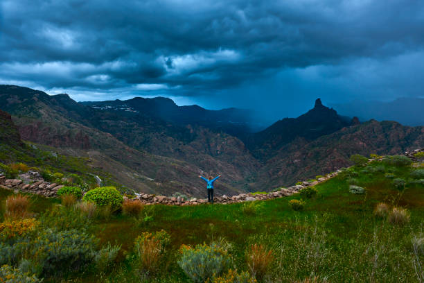 rear view of hiker woman in Grand Canary mountains feeling so free.rear view, stormy sky.
