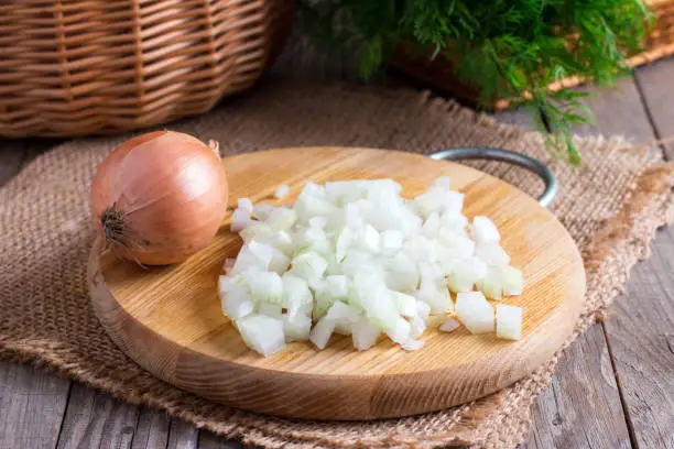 Raw onion, chopped very small cubes on a wooden board