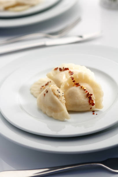 istock Elegant russian dumplings with red pepper lay on white tableware in luxury restaurant. 845874580