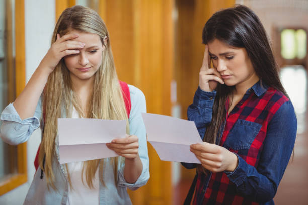 Anxious students looking at results Anxious students looking at results at university test results stock pictures, royalty-free photos & images