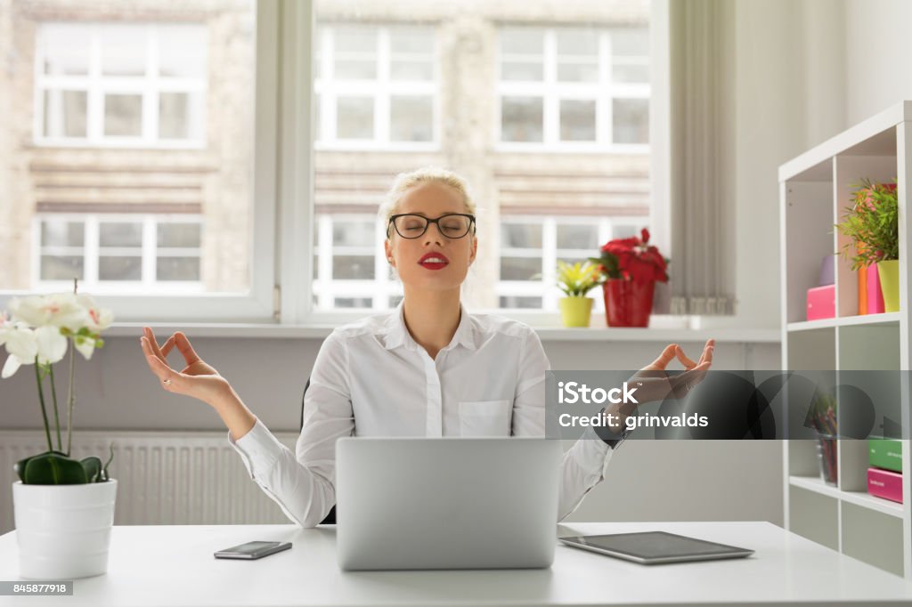 Woman in office meditating Emotional Stress Stock Photo