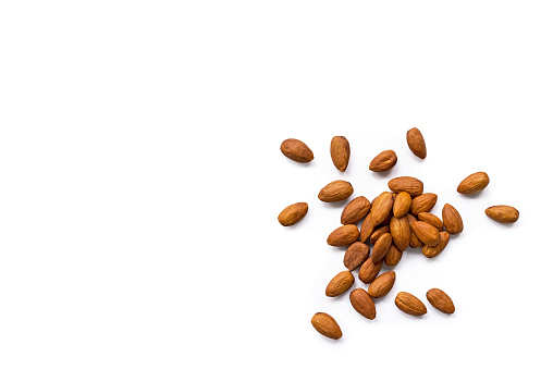 beautiful pile of roasted organic almonds with the peel isolated on a white background. Horizontal composition. Top view