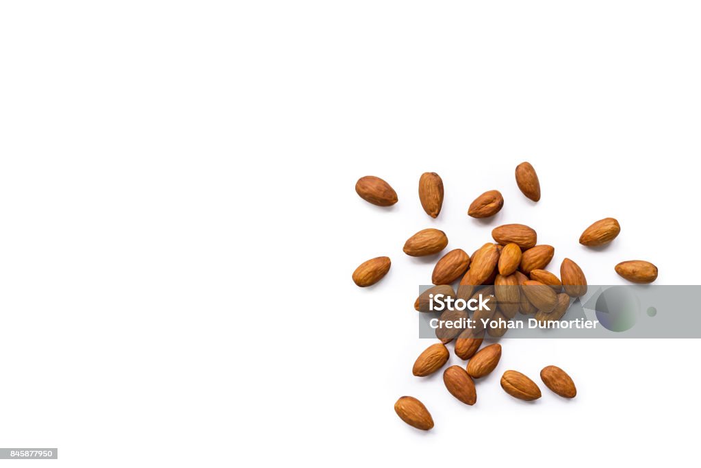 beautiful pile of roasted organic almonds with the peel isolated on a white background. beautiful pile of roasted organic almonds with the peel isolated on a white background. Horizontal composition. Top view Almond Stock Photo