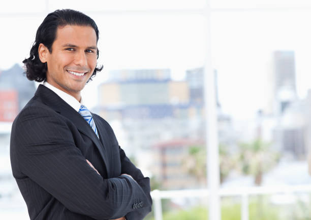 executive standing upright in front of a window and looking towards the side - job search fotos imagens e fotografias de stock