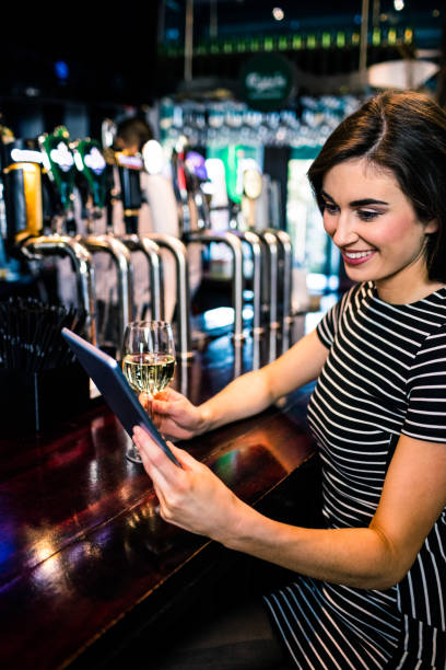 istock Woman using tablet and having a glass of wine 845889410