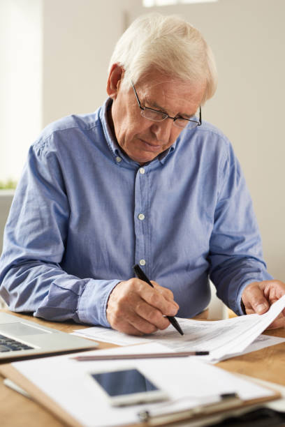 istock Senior Man Writing Tax Report 845900548