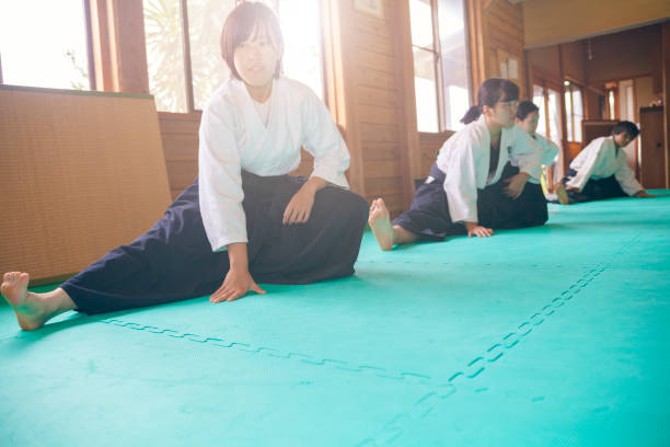 Warming Up Before Practice Three martial art practitioners are warming up before practicing. japan women human foot japanese culture stock pictures, royalty-free photos & images
