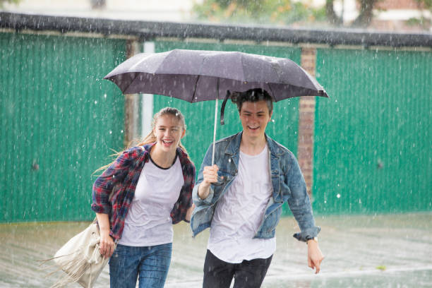 istock Young Couple Run In The Rain 845904014