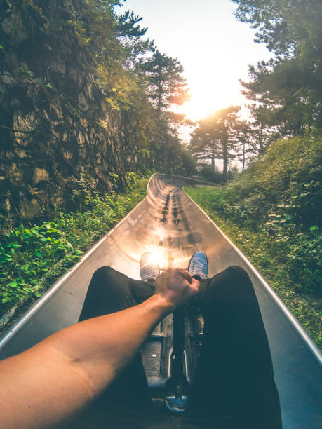 Toboggan Ride Point of View Point of view shot of a young man riding a toboggan during sunset. mutianyu toboggan stock pictures, royalty-free photos & images