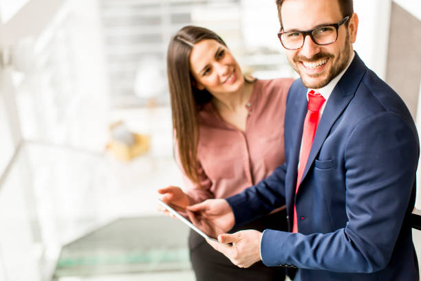 istock Young business couple working on tablet on stairs 845911972