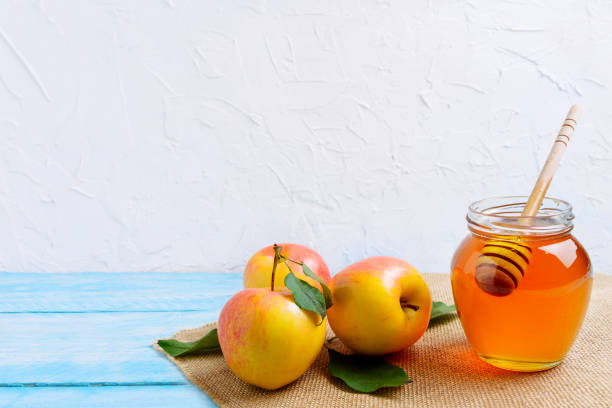 Honey jar with and apples copy space