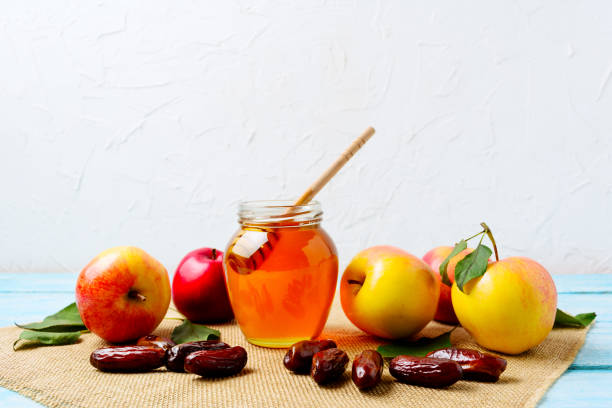 istock Honey jar, dates and ripe apples on burlap napkin 845914574