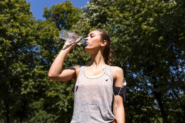 istock Pretty young woman drinking water during exercise 845914904